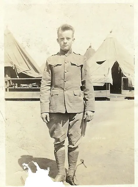 A man in uniform standing next to tents.