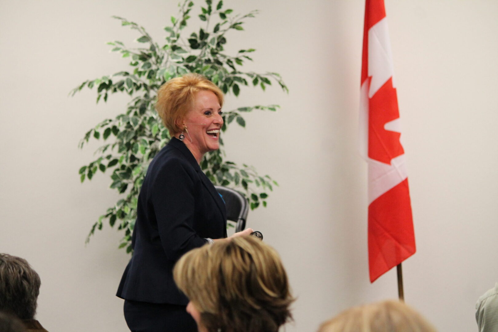 A woman standing in front of a canadian flag.