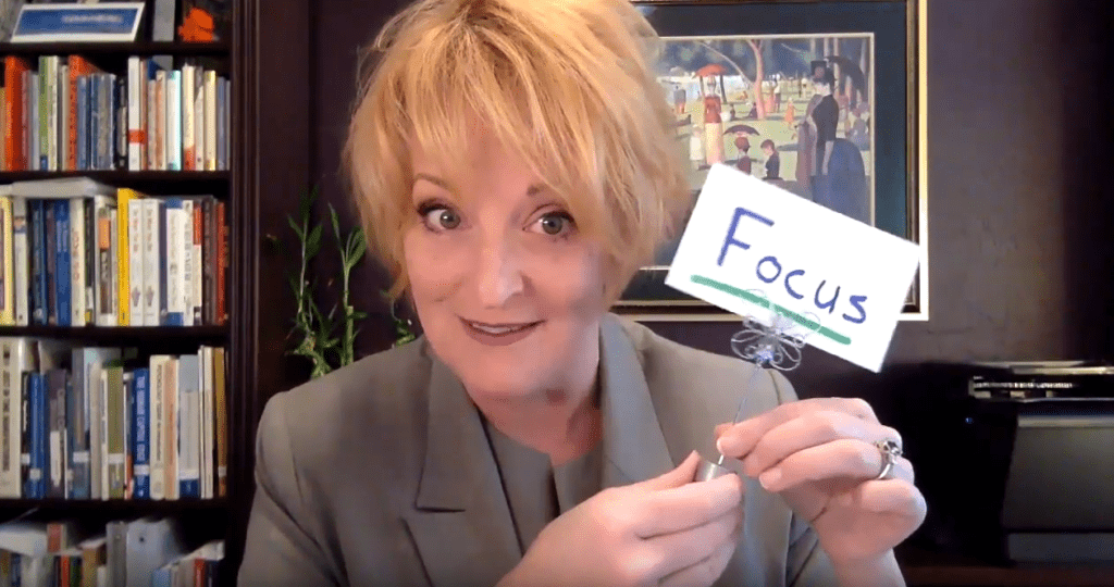 A woman holding a sign that says focus.